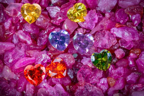生のスカイブルーの宝石に置かれたイエローハートダイヤモンドとレッドルビーハートダイヤモンド ハート形のジュエリーはバレンタインデーのために素敵なプレゼントです — ストック写真