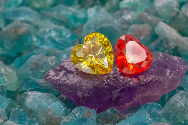 生のスカイブルーの宝石に置かれたイエローハートダイヤモンドとレッドルビーハートダイヤモンド ハート形のジュエリーはバレンタインデーのために素敵なプレゼントです — ストック写真