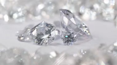 Çeşitli boyutlarda beyaz elmaslar, beyaz elmaslarla çevrili beyaz bir arka planda dönen bir merkez daireye yerleştirilir..