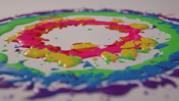 滴落在白色地面上 并在圆圈中扩散开来的颜色在旋转着 — 图库视频影像