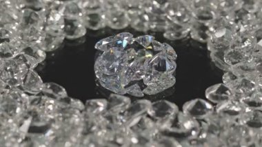 Ayna merkezindeki farklı şekillerde ve farklı boyutlarda elmaslar siyah arka planda dönüyorlar..