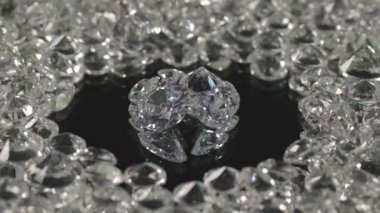 Ayna merkezindeki farklı şekillerde ve farklı boyutlarda elmaslar siyah arka planda dönüyorlar..