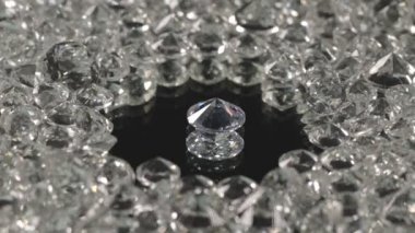 Ayna merkezindeki farklı şekillerde ve farklı boyutlarda elmaslar siyah arka planda dönüyorlar..