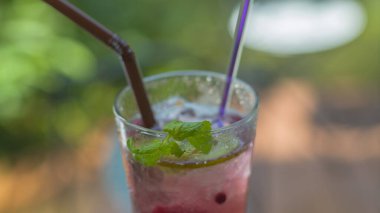 Üzüm suyu, kivi ve soda şeffaf bir bardağa buz koyar.