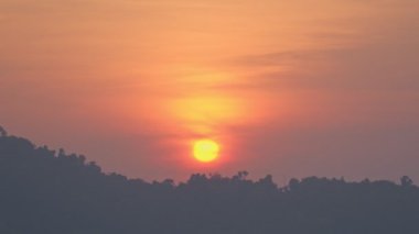 Büyük sarı güneş, sabah dağın zirvesinin üstündeki kırmızı gökyüzünde parlıyor. Phang Nga Eyaleti 'nin birçok büyük ve küçük tepeleri vardır. Ve sabahları yağışlı hava genellikle bir sis denizi yaratır..