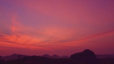 Güzel kızıl gökyüzü dağların tepesinde gündoğumunda mükemmel bir ormanla