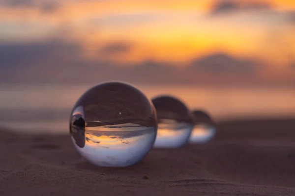 Three clear crystal balls of three sizes are sphere reveals  seascape view with spherical