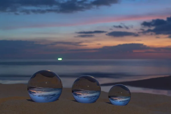 Three clear crystal balls of three sizes are sphere reveals  seascape view with spherical