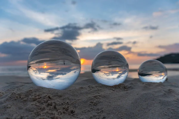 Three clear crystal balls of three sizes are sphere reveals  seascape view with spherical