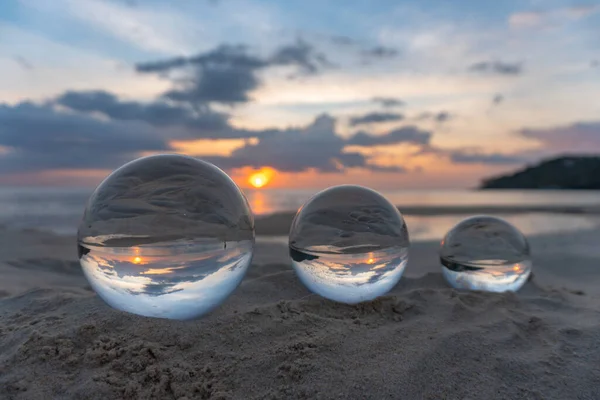 Three clear crystal balls of three sizes are sphere reveals  seascape view with spherical