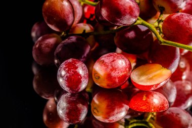 Üzümler siyah bir arka planla aynanın yarısından kesilmiş.