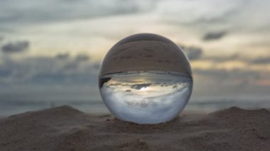 Sahildeki kristal kürenin üzerindeki muhteşem gökyüzü. Plajdaki kristal kürenin üzerindeki gökyüzünün güzel yansıması.