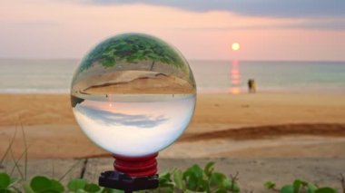 Kristal kürede gün batımı ters dönmüş bir şekilde görünen görüntü Karon plajı Phuket Tayland 'da tuhaf görünüyor...