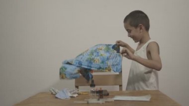 Tatlı çocuk beyaz bir arka planda beyaz bir atletin üzerine Hawaii gömleği giymekten hoşlanıyordu. Stüdyoda Kara Büyü 6K kamerasıyla çekim yap..
