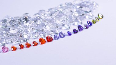 Kalp şeklinde renkli elmas beyaz elmas arka planda bir sıraya konur.,