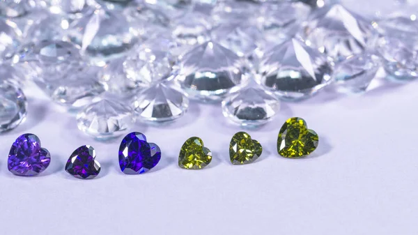 ハート型のカラフルなダイヤモンドが白いダイヤモンドの背景に列に配置されています — ストック写真