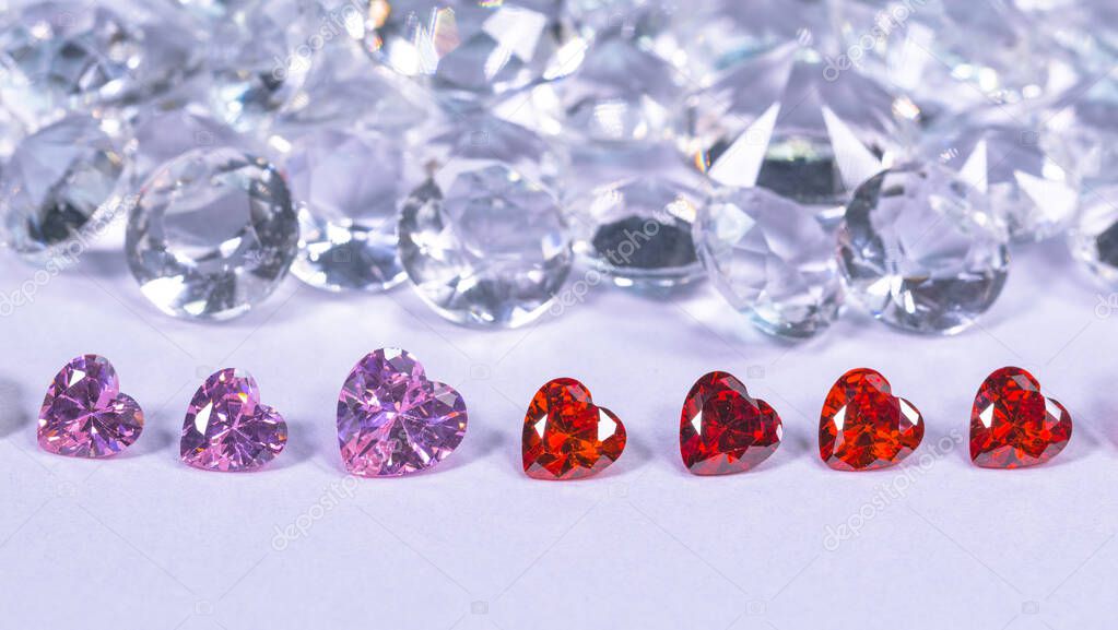 colorful diamond in heart shape are placed in a row on white diamonds background,