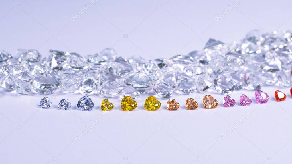 colorful diamond in heart shape are placed in a row on white diamonds background,