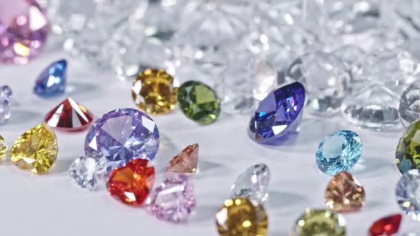 白いダイヤモンドの背景を持つ白い床に置かれたカラフルな宝石 高品質のビデオショット — ストック動画