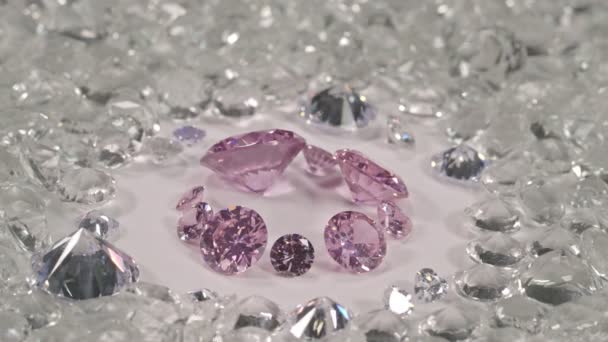 ピンクサファイアは大きさも形も違うダイヤモンドで 切り出されていない赤いガーネットの石に囲まれた白い地面の真ん中に多くの形があります — ストック動画