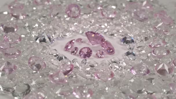 ピンクサファイアは大きさも形も違うダイヤモンドで 切り出されていない赤いガーネットの石に囲まれた白い地面の真ん中に多くの形があります — ストック動画