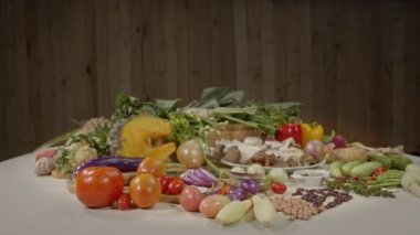   Taze sebzeler, baharatlar ve farklı türde mantarlar arka planda ahşap bir sahne ile beyaz bir masaya yerleştirilir. yüksek kaliteli 4K video