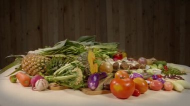 Sağlıklı vejetaryen yemek malzemeleri hazırlıyorum. Taze sebzeler, baharatlar ve farklı türde mantarlar arka planda ahşap bir sahne ile beyaz bir masaya yerleştirilir. yüksek kaliteli 4K video