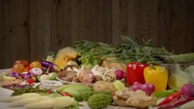 Sağlıklı vejetaryen yemek malzemeleri hazırlıyorum. Taze sebzeler, baharatlar ve farklı türde mantarlar arka planda ahşap bir sahne ile beyaz bir masaya yerleştirilir. yüksek kaliteli 4K video
