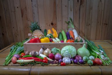 Baharatlar ve farklı mantarlar beyaz bir masaya yerleştirilir ve arka planda ahşap bir sahne bulunur.. 