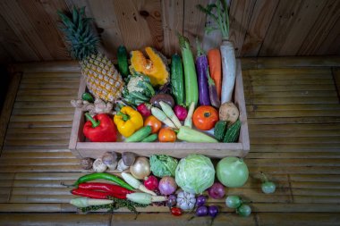 Baharatlar ve farklı mantarlar beyaz bir masaya yerleştirilir ve arka planda ahşap bir sahne bulunur.. 