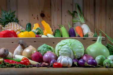 Baharatlar ve farklı mantarlar beyaz bir masaya yerleştirilir ve arka planda ahşap bir sahne bulunur.. 