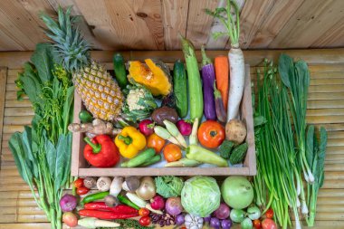 Baharatlar ve farklı mantarlar beyaz bir masaya yerleştirilir ve arka planda ahşap bir sahne bulunur.. 