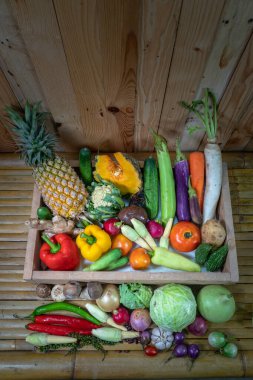 Baharatlar ve farklı mantarlar beyaz bir masaya yerleştirilir ve arka planda ahşap bir sahne bulunur.. 