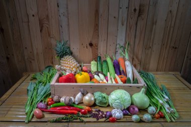 Baharatlar ve farklı mantarlar beyaz bir masaya yerleştirilir ve arka planda ahşap bir sahne bulunur.. 