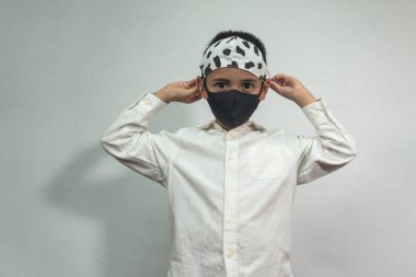 Yüzünde maske olan beyaz bir çocuk. Virüs ve enfeksiyona karşı koruma. Stüdyo portresi, beyaz arkaplan konsepti