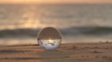 Yengeçler gün batımında kristal kürenin etrafında yürürler. Gün batımında sahildeki yengeçlerin doğal manzarası alışılmadık ve güzeldir. Eşsiz ve yaratıcı bir seyahat fikri..