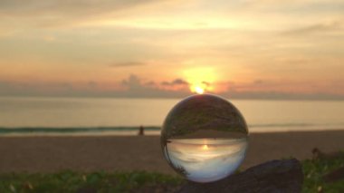 Gün batımında sahilde kristal küre 