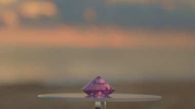 Pembe elmas vitrine konur ve dönmeye devam eder. Video 4k... deniz arka planında 4K günbatımı yüksek kaliteli video