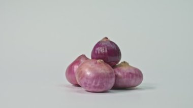 Kırmızı soğanın biraz daha tatlı tadı sağlıklı organik narları bitirir. Beyaz arka planda yüksek kaliteli video 4K Shallots. Stüdyo çekimi.
