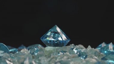 Aquamarine mavi elması, siyah arkaplandaki işlenmemiş mavi taşların üzerine yerleştirilmiş. Video 4k.high quality video 4K ham mavi taşlar arka plan.