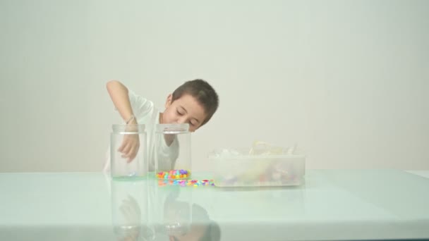 Egy Aranyos Fiú Boldogan Játszott Sokszínű Gyöngyök Fehér Szobában Kiváló — Stock videók