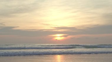 Deniz ve plaj üzerinde gündoğumu. Dalgalar kum yıkama.