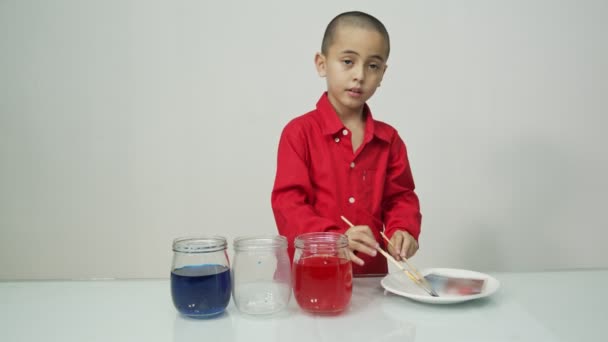ガラス瓶にオレンジを注ぐかわいい少年 — ストック動画