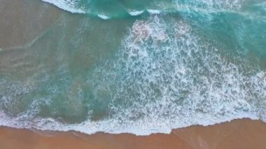 Hava üst görüntüsü dalga dalga sahile doğru sürüklendi. Sahildeki deniz kumu manzarası ve yaz günü dalga. Sahildeki deniz alanı. Mavi deniz, dalgalar Karon Sahili 'ne çarpıyor, Phuket. 