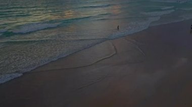  Dalgalar yavaşça kıyıya doğru süzüldü.