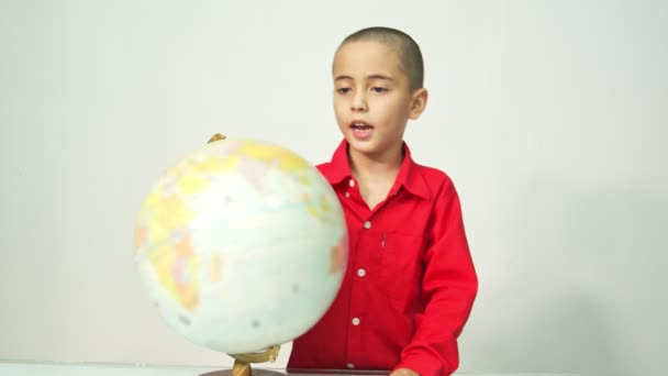 Menino Com Skinhead Uma Camisa Vermelha Está Girando Globo Menino — Vídeo de Stock