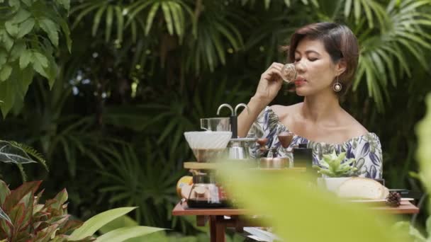 Μια Γυναίκα Χαλαρώστε Στον Καταπράσινο Κήπο Καφέ — Αρχείο Βίντεο
