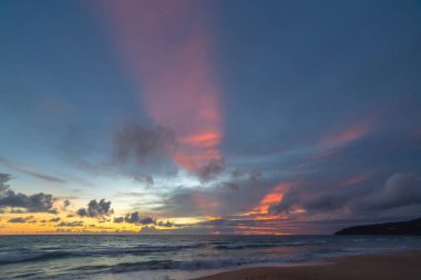 A beautiful sight of beams of light rising into the sky at dusk.sweet sky in sunset above the ocean at Karon beach Phuket. Sunset with sweet color light rays and other atmospheric effects.