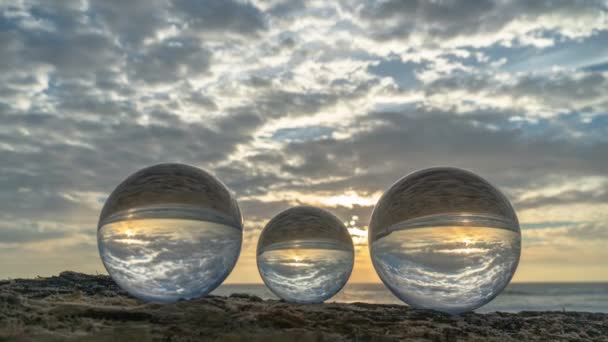 在三个水晶球内的时间落日在海面上放置在海滩视频4K旁边的木材上 自然录像高质量的镜头在大自然和旅行概念中日以继夜地消失 — 图库视频影像