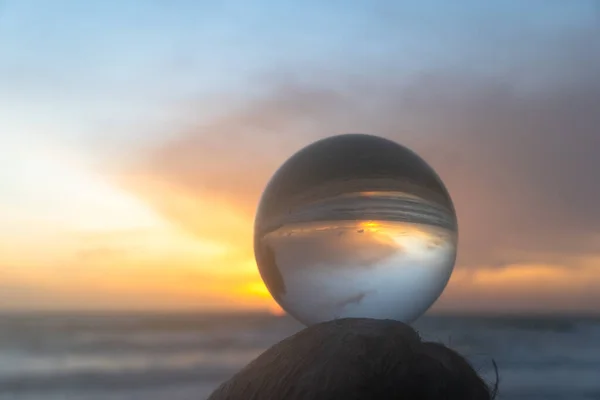 view of the island at sunset inside crystal ball on a pile of sand.sunset over sea in a crystal ball place on the beach. Nature video High quality photo in nature and travel concept.